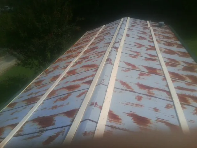 Rusted metal roof panels with new wood purlins before replacement — Storm Damage Roof Repair in Claxton by Roofing Brothers