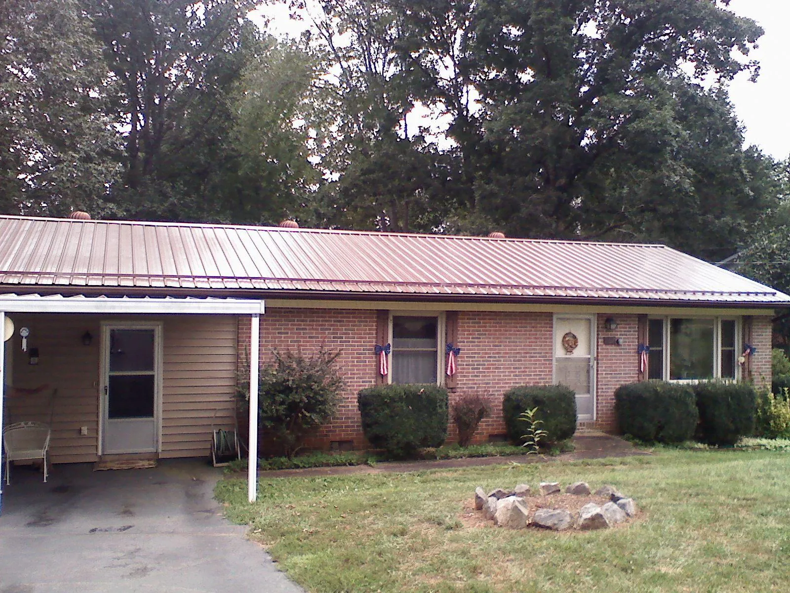 Bronze metal roof and carport on a brick ranch home — Roof Repair work by our crew in Claxton