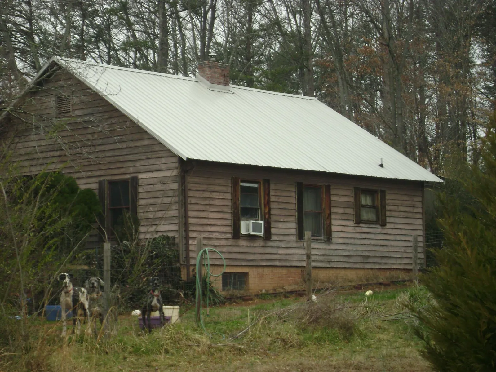 White metal roof on an old wood sided farmhouse, from a Metal Roof Installation job in Claxton